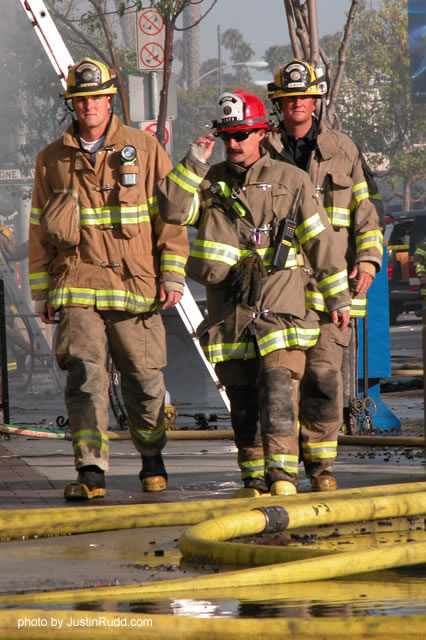 Yellow hoses lie about as tons of water flow within them to douse the flames in Belmont Shore.